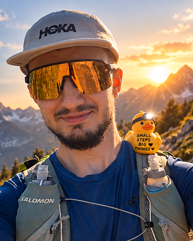 Rafał on a mountain ridge at sunset, HOKA cap, orange sunglasses, running vest